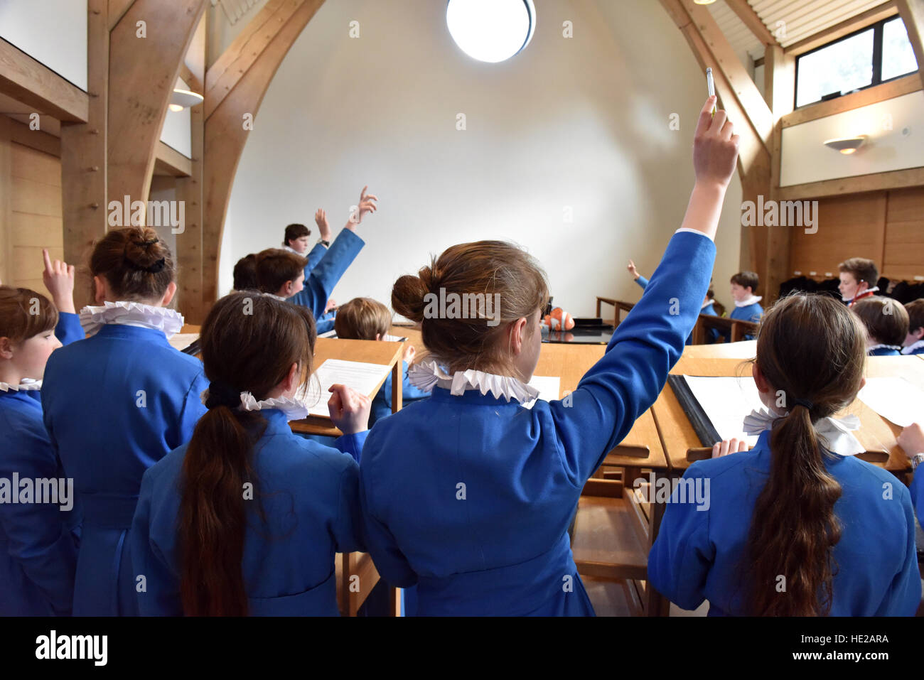 Choristers answerong questions from the choir master during rehearsal for a service. Stock Photo