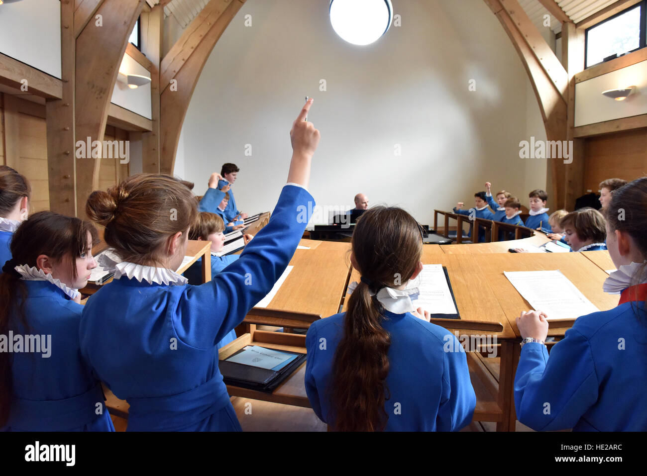 Choristers answerong questions from the choir master during rehearsal for a service. Stock Photo