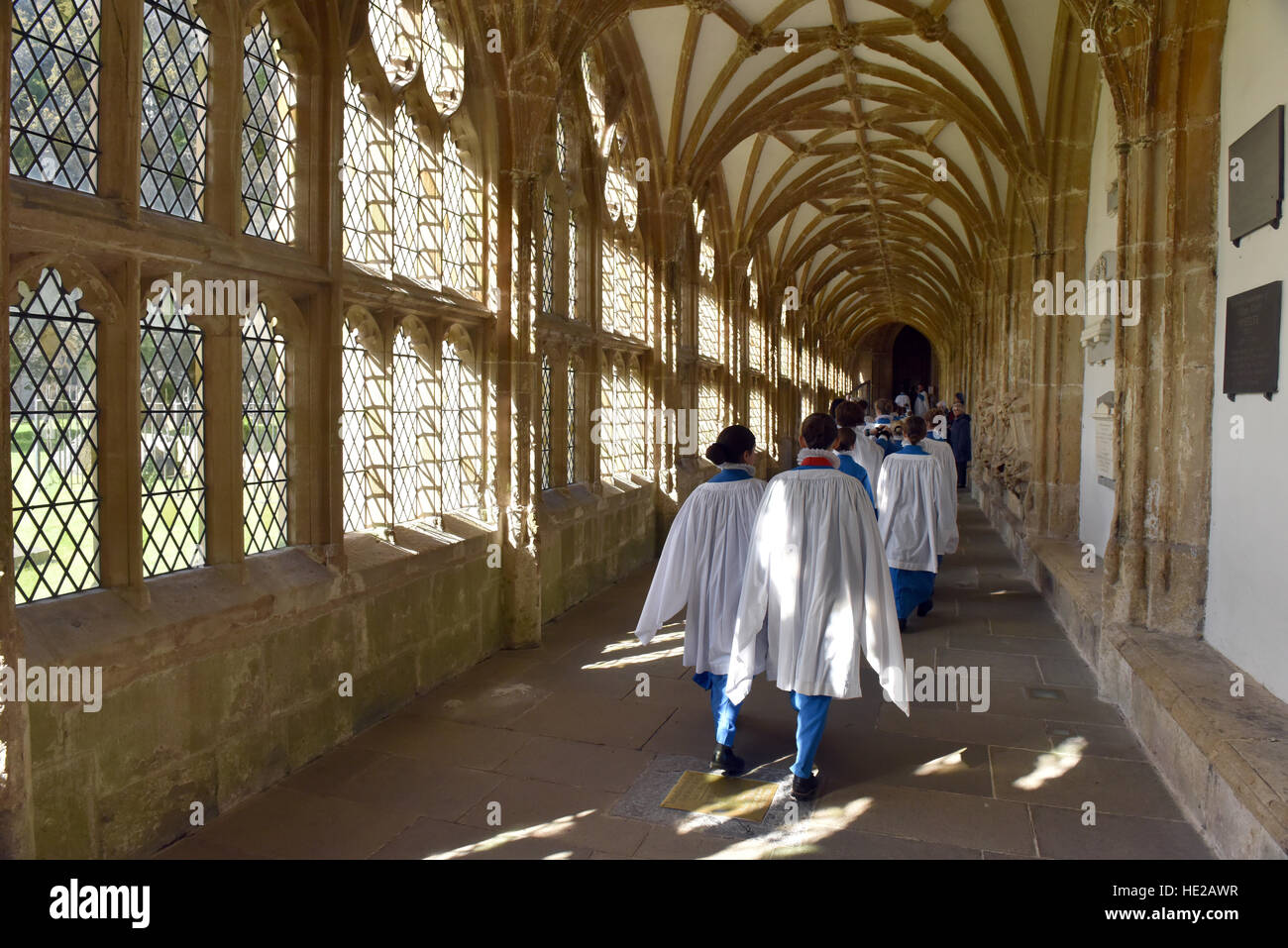 Wells Cathedral Choir choristers walking along the cloisters at Wells Cathedral before Evensong on Easter day. Stock Photo