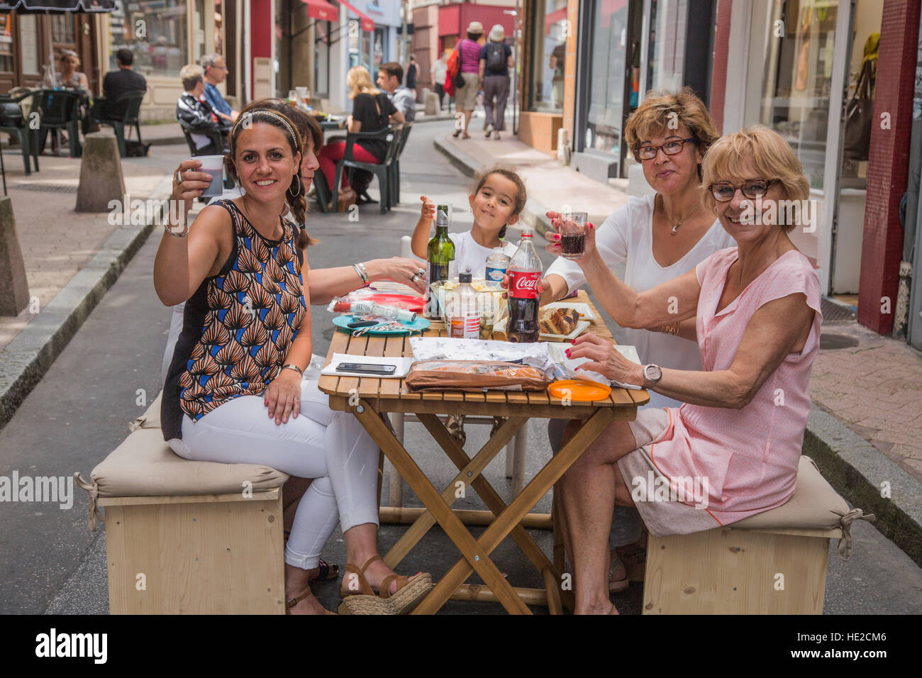 Happy family eating lunch at a table in pedestrian street in town of Limoges France Stock Photo