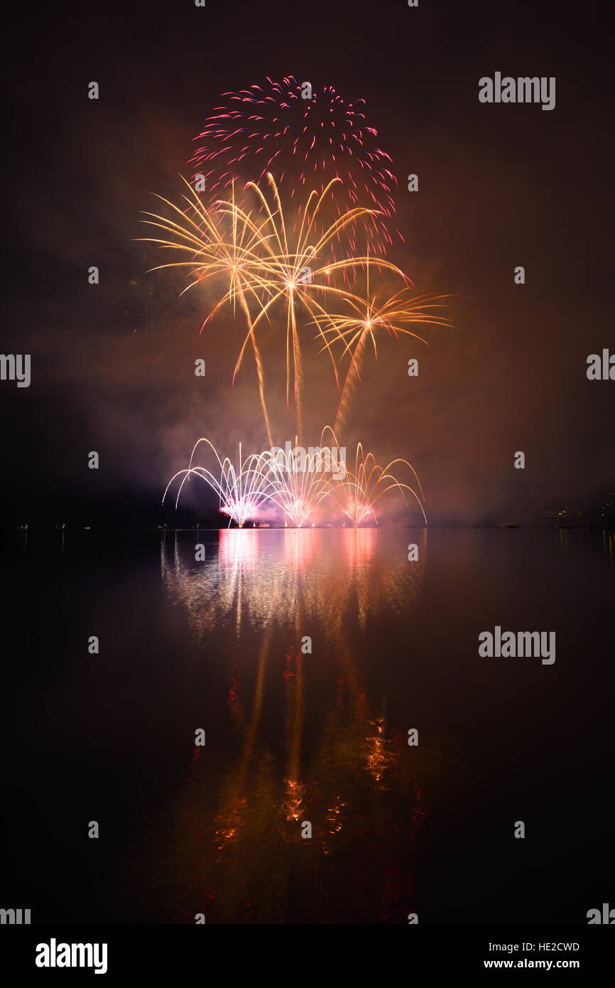 Colorful spectacular fireworks reflecting in water Stock Photo