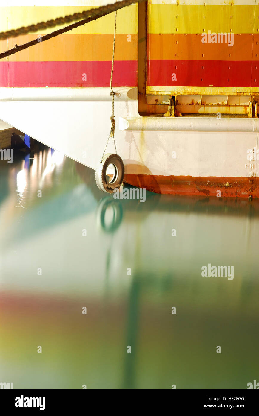 Old retired colorful ferry boat with calm sea water Stock Photo