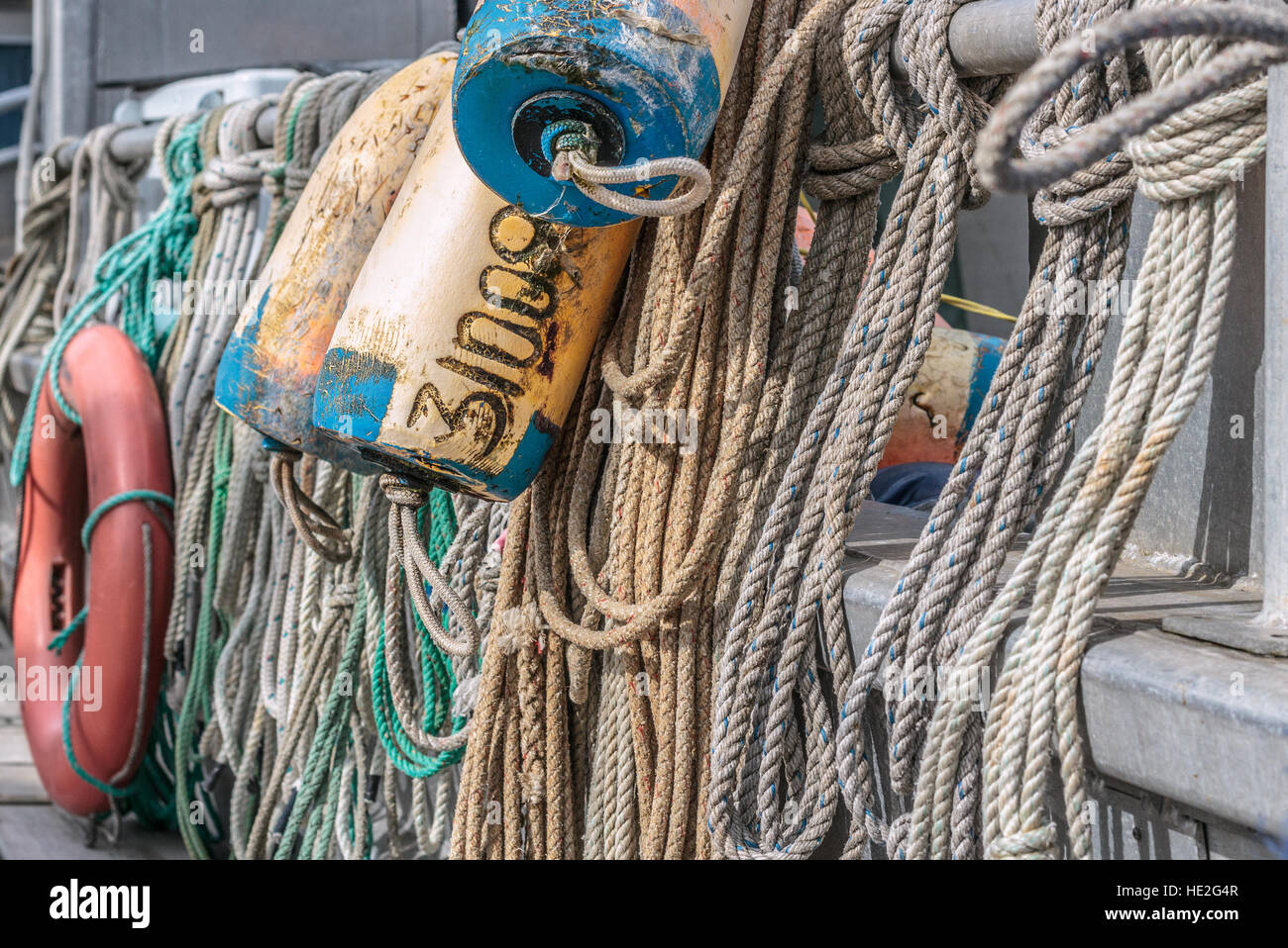 A close view of ropes, floats and a life ring hanging from the rail of a commercial fishing boat on Canada's west coast. Stock Photo