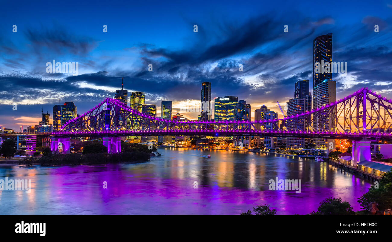 Vibrant night time panorama of Brisbane city with purple lights on Story Bridge, Australia Stock Photo
