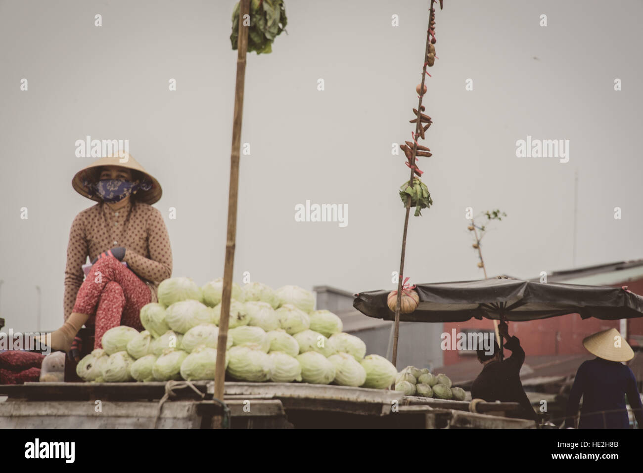 Vietnamese market seller on a boat on Mekong river - selling cabbages Stock Photo