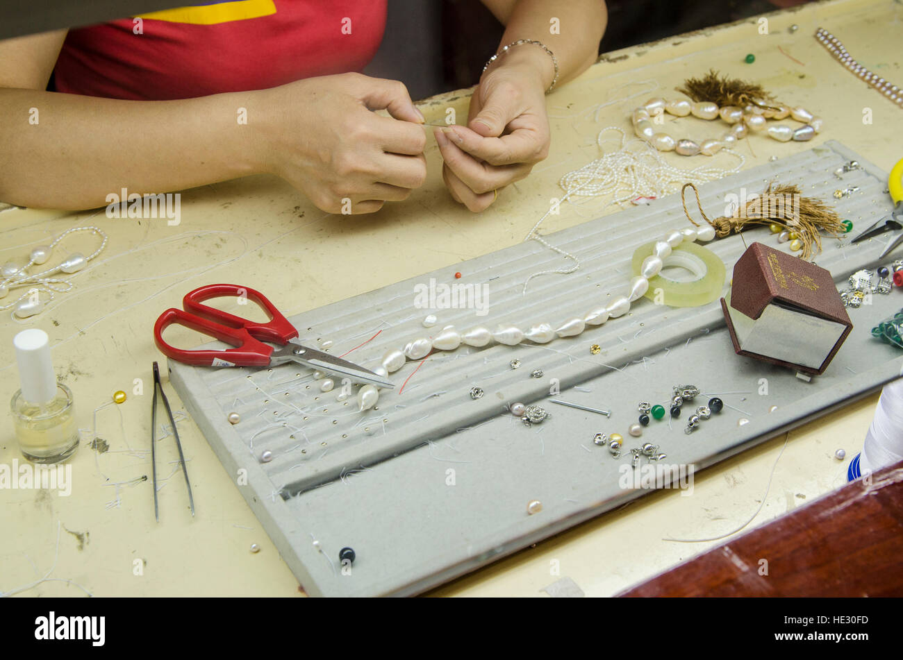 Factory workers stringing pearls at a pearl factory Guilin, China. Stock Photo