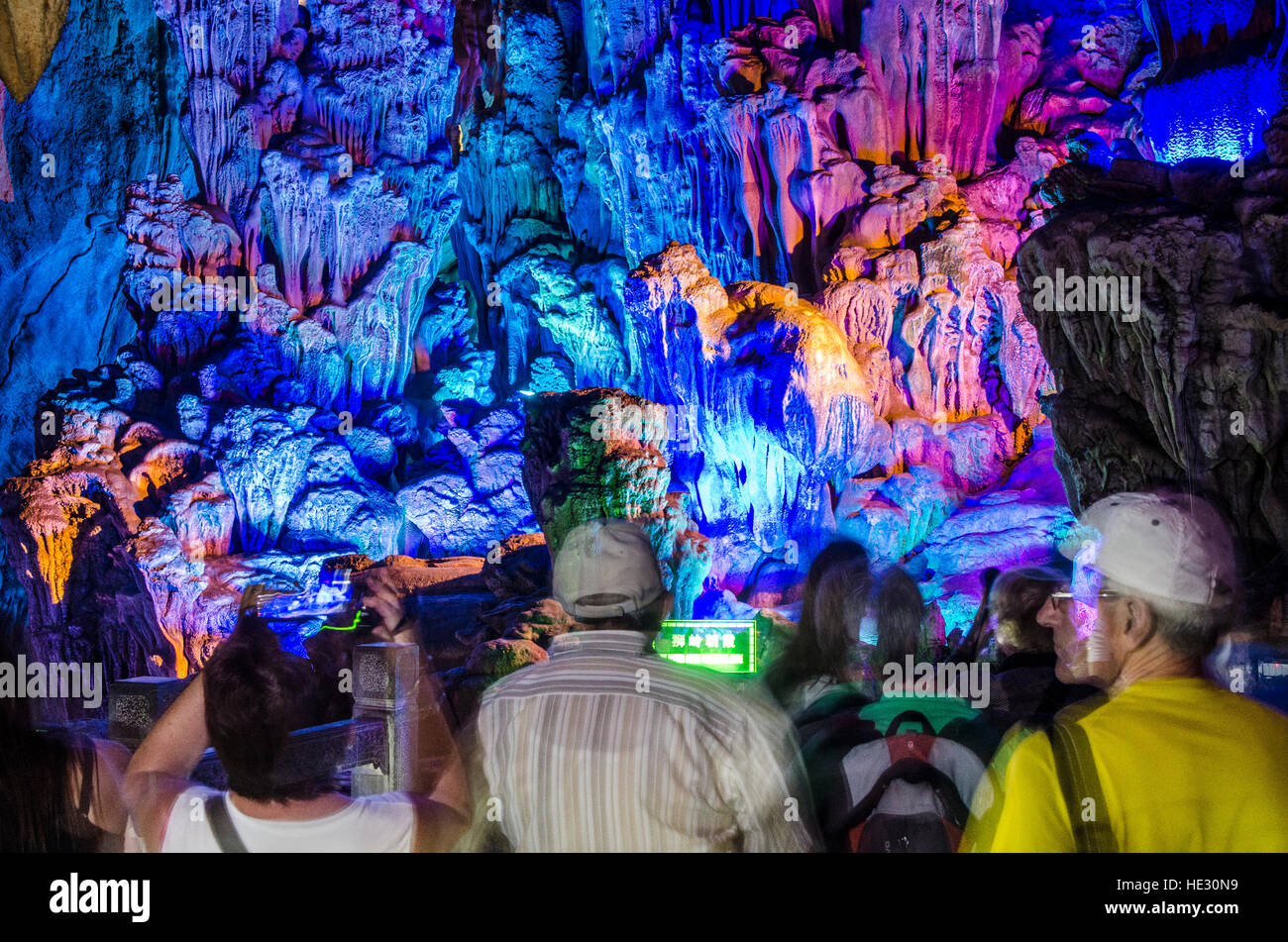 People viewing stalagmites and stalactites in Reed Flute Cave Guilin, China. Stock Photo