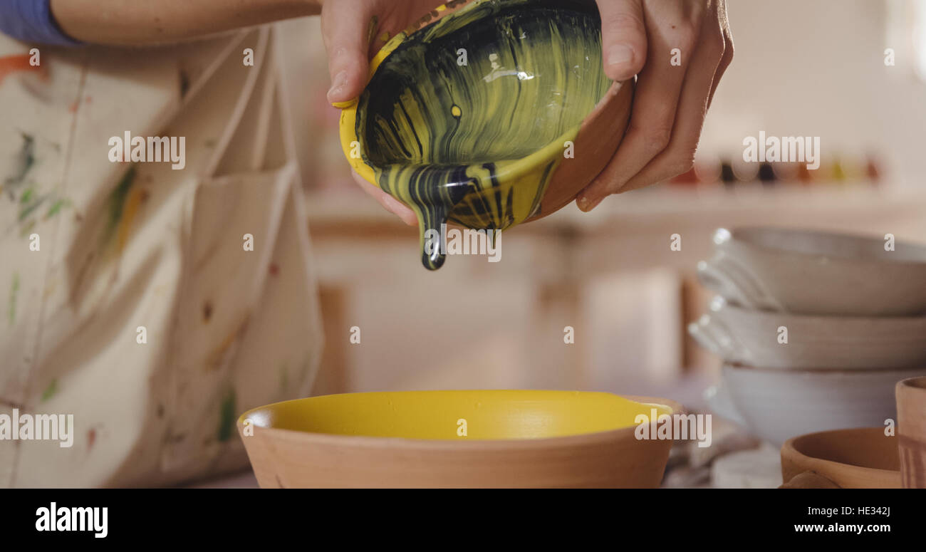 Close-up of potter pouring watercolor in bowl in pottery workshop Stock ...