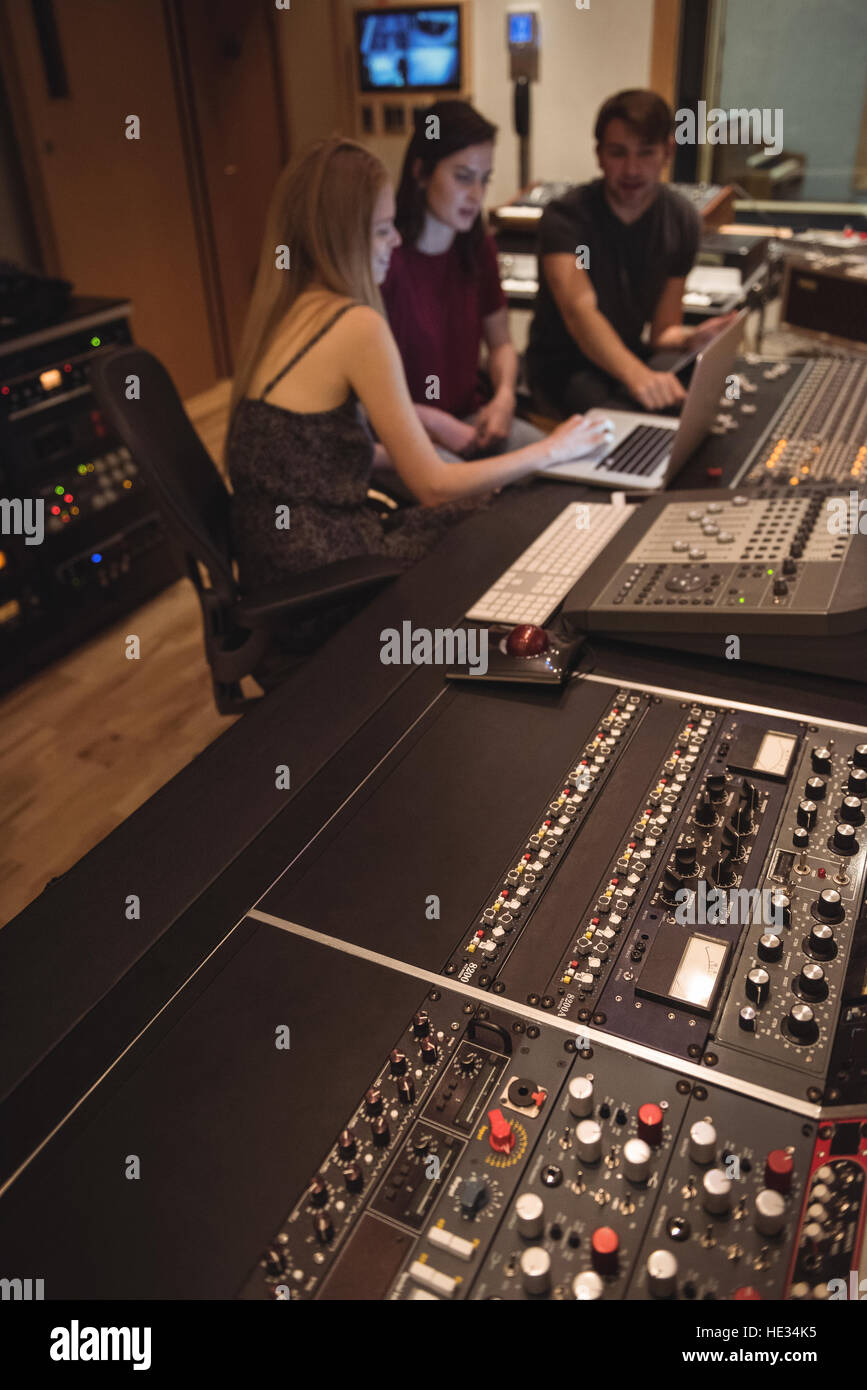 Audio engineers using laptop near sound mixer in music studio Stock ...