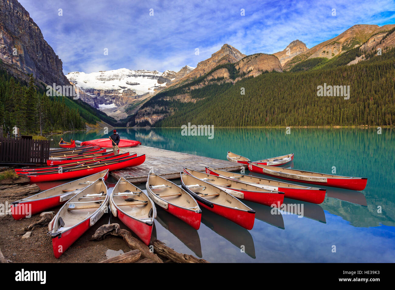 Red canoes for rent beside the dock at Lake Louise boat house in Banff National Park Alberta Canada Stock Photo