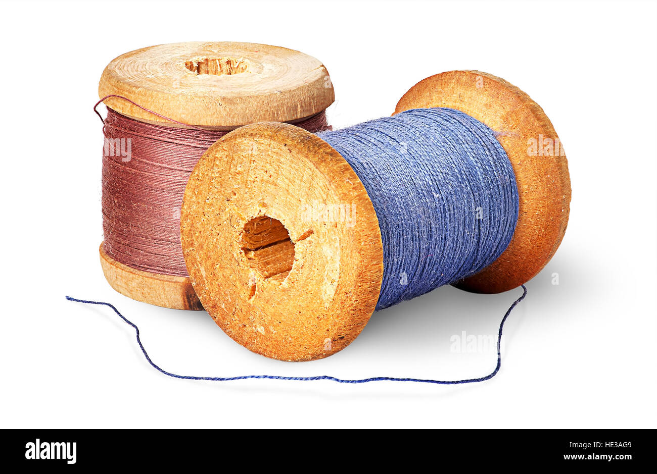 Two different colored thread on wooden spools isolated on white background Stock Photo