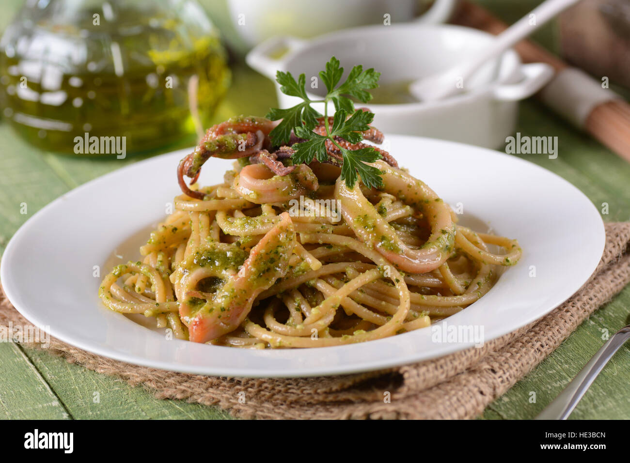spaghetti with pesto sauce and squid - traditional Italian recipe Stock