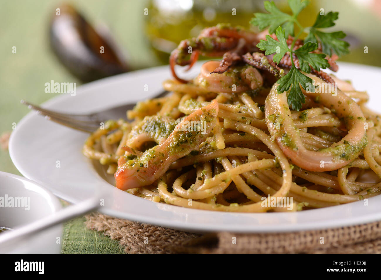 spaghetti with pesto sauce and squid - traditional Italian recipe Stock