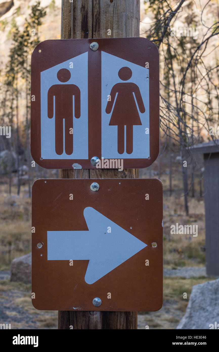 Brown and white sign for public restrooms at a state park...probably outhouses Stock Photo