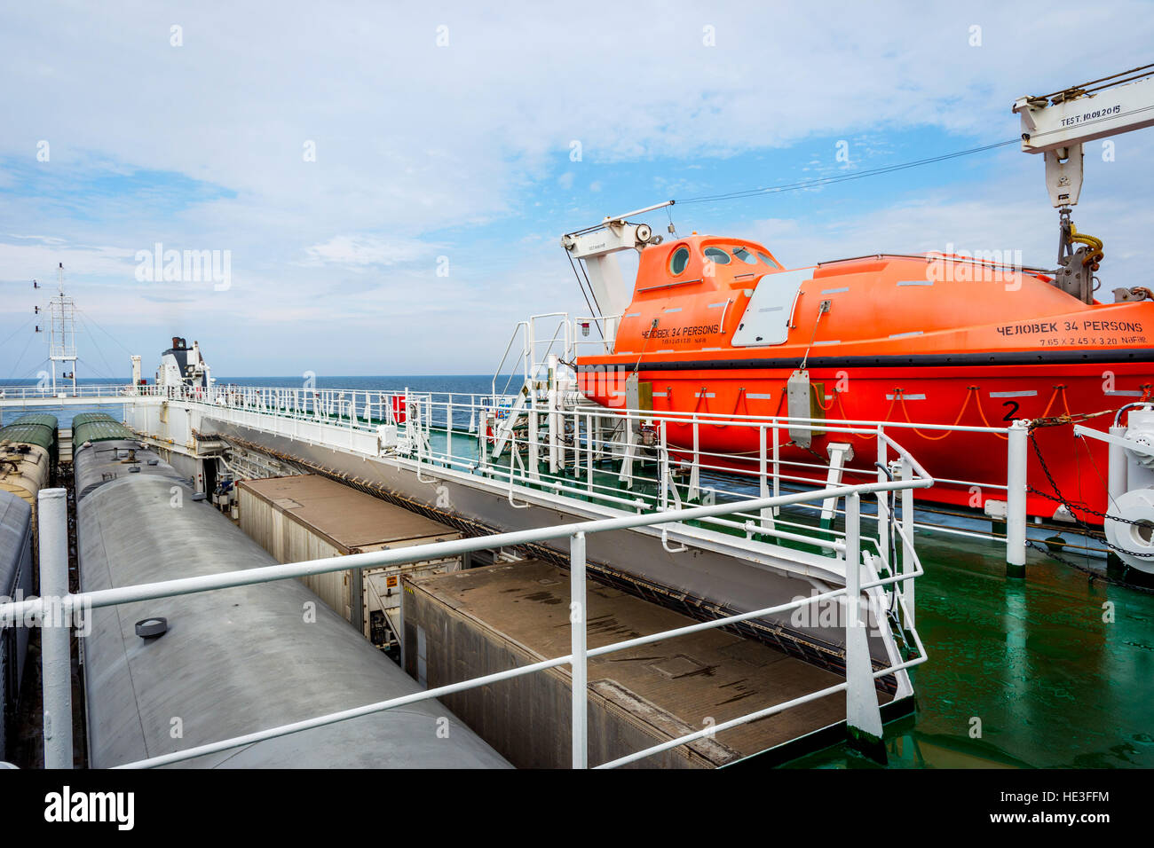 Orange rescue boat on the cargo vessel at the sea Stock Photo