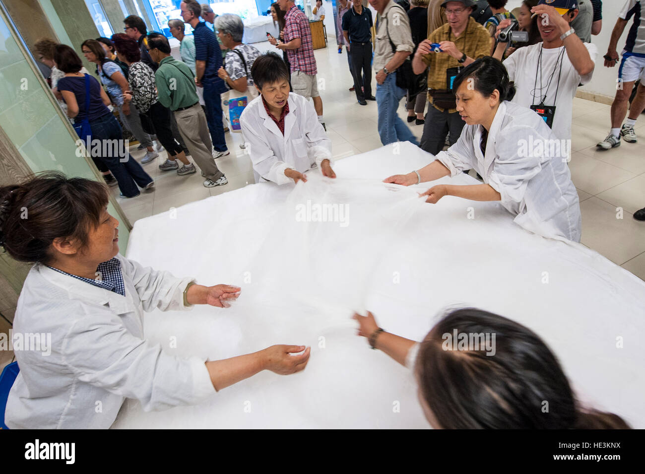 Silk factory workers stretching silk cloth at SIlk Spinning Mill Suzhou, China. Stock Photo