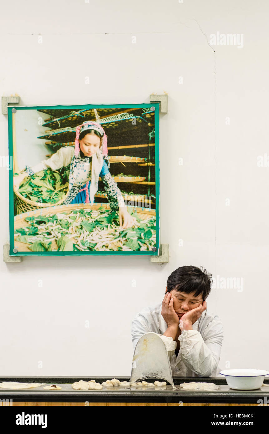 Silk cocoon inspector production factory worker naps napping at the Silk Spinning Mill Suzhou, China. Stock Photo