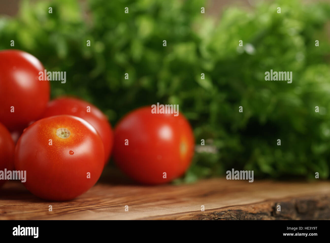 cherry tomatoes and frisee lettuce on cutting board Stock Photo - Alamy