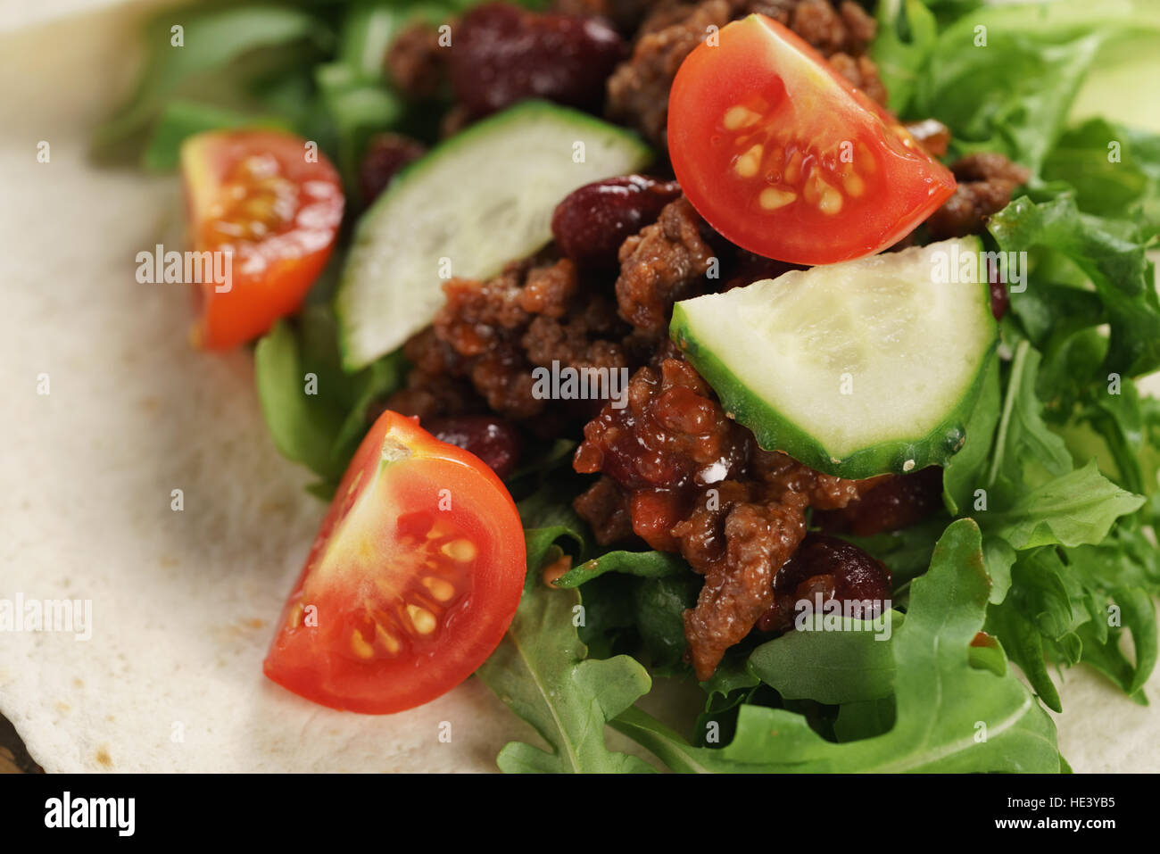 preparing homemade open tortilla with beef, frisee and vegetables Stock Photo