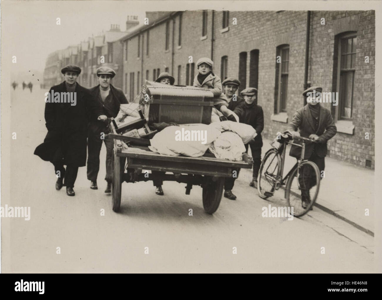 This historical image from 1922 depicts a hand cart being used during an evacuation in Hartlepool, where furniture and personal belongings were transported following a fire. It captures a moment from the past, showcasing the urgency of the evacuation process and the tools used during such emergencies. Stock Photo