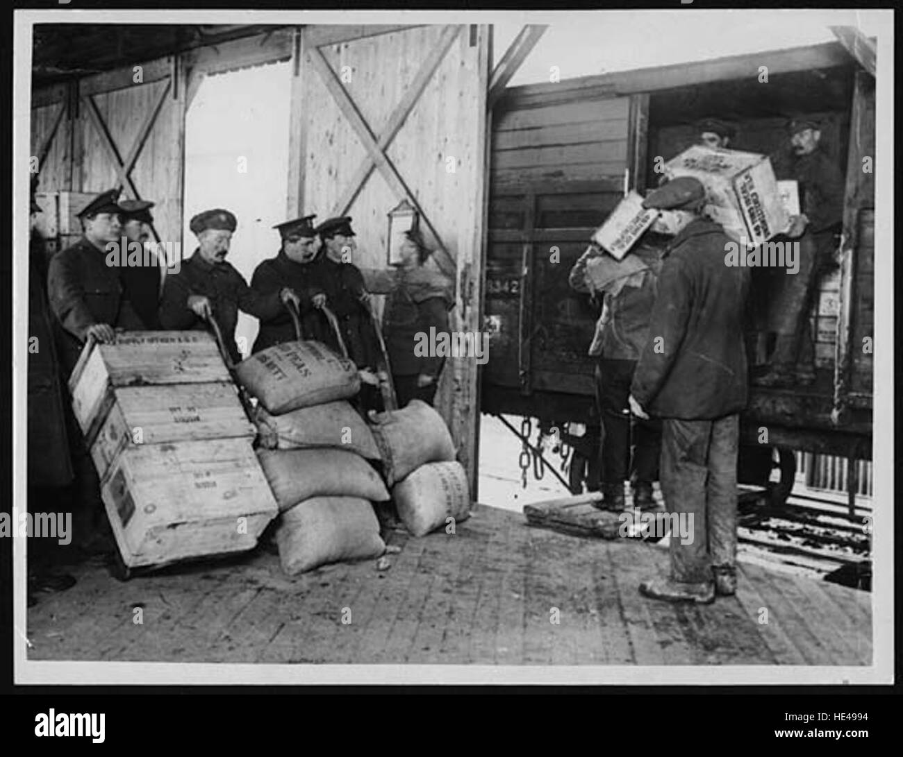 This historical image shows the process of loading stores from a shed into a train, capturing a bygone era of industry and transportation. It represents the logistical efforts of the past and the historical methods of transferring goods via train. Stock Photo