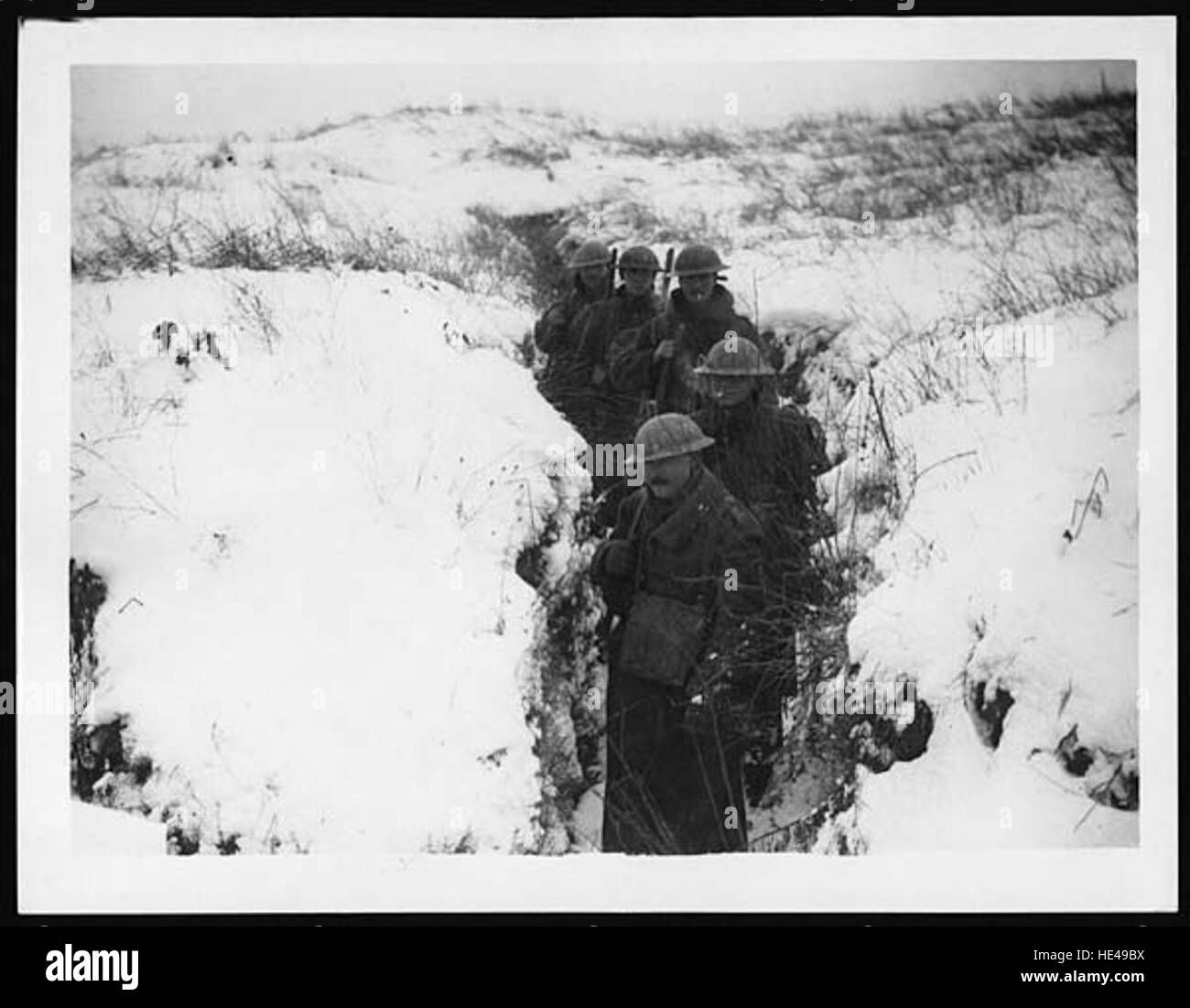 This historical image captures a snowy scene at the front during a past war, depicting soldiers in a cold and harsh environment. The image reflects the hardships of military life during wartime, highlighting the extreme conditions faced by soldiers. Stock Photo