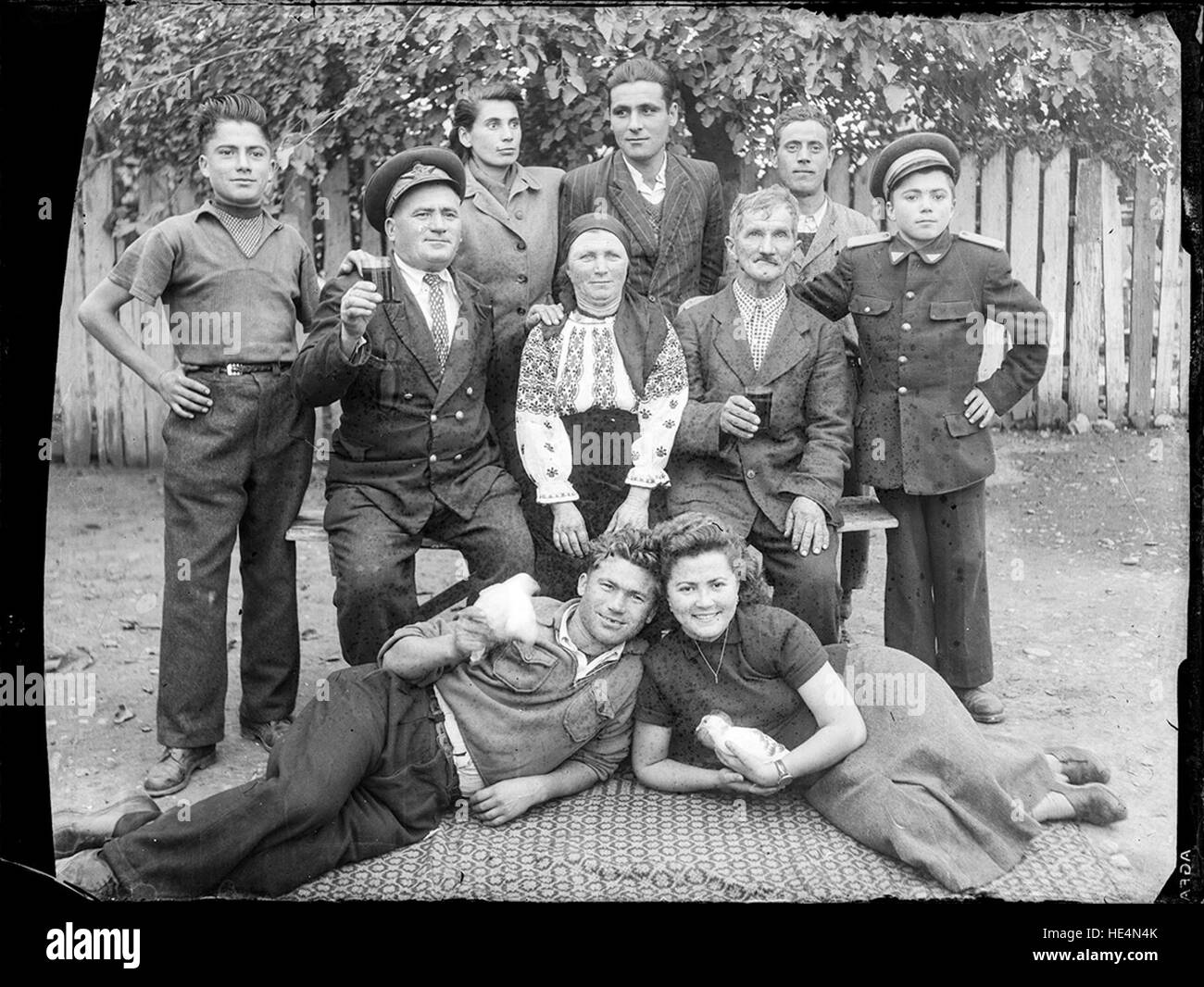 Grup (Tatăl ceferist, uniformă model 1939 şi-a echipat fiul în uniformă CFR.  Posibil ca uniforma să aparţină unei şcoli patronate de calea ferată,  astfel copii fiind uniformizaţi în ţinuta şcolii Stock Photo -