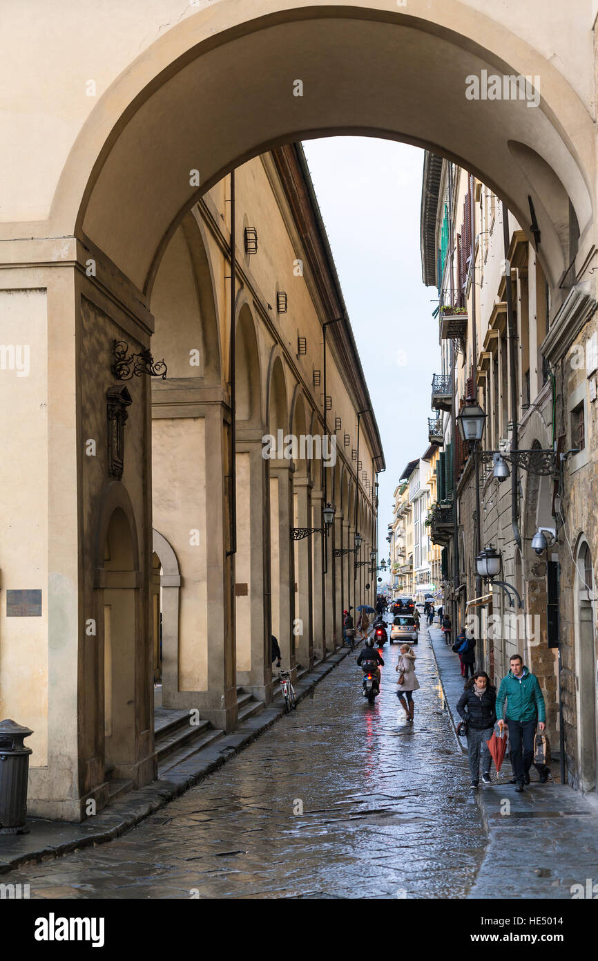 FLORENCE, ITALY - NOVEMBER 5, 2016: tourists near Vasari Corridor on Lungarno Anna Maria Luisa de Medici in rain. The Vasari Corridor connects Palazzo Stock Photo
