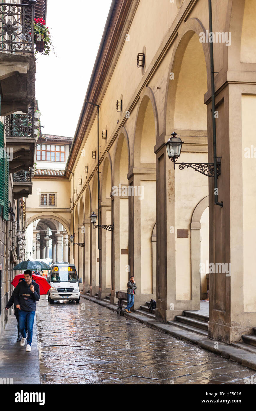 FLORENCE, ITALY - NOVEMBER 5, 2016: people near Vasari Corridor on Lungarno degli Archibusieri in rain. The Vasari Corridor connects Palazzo Vecchio w Stock Photo