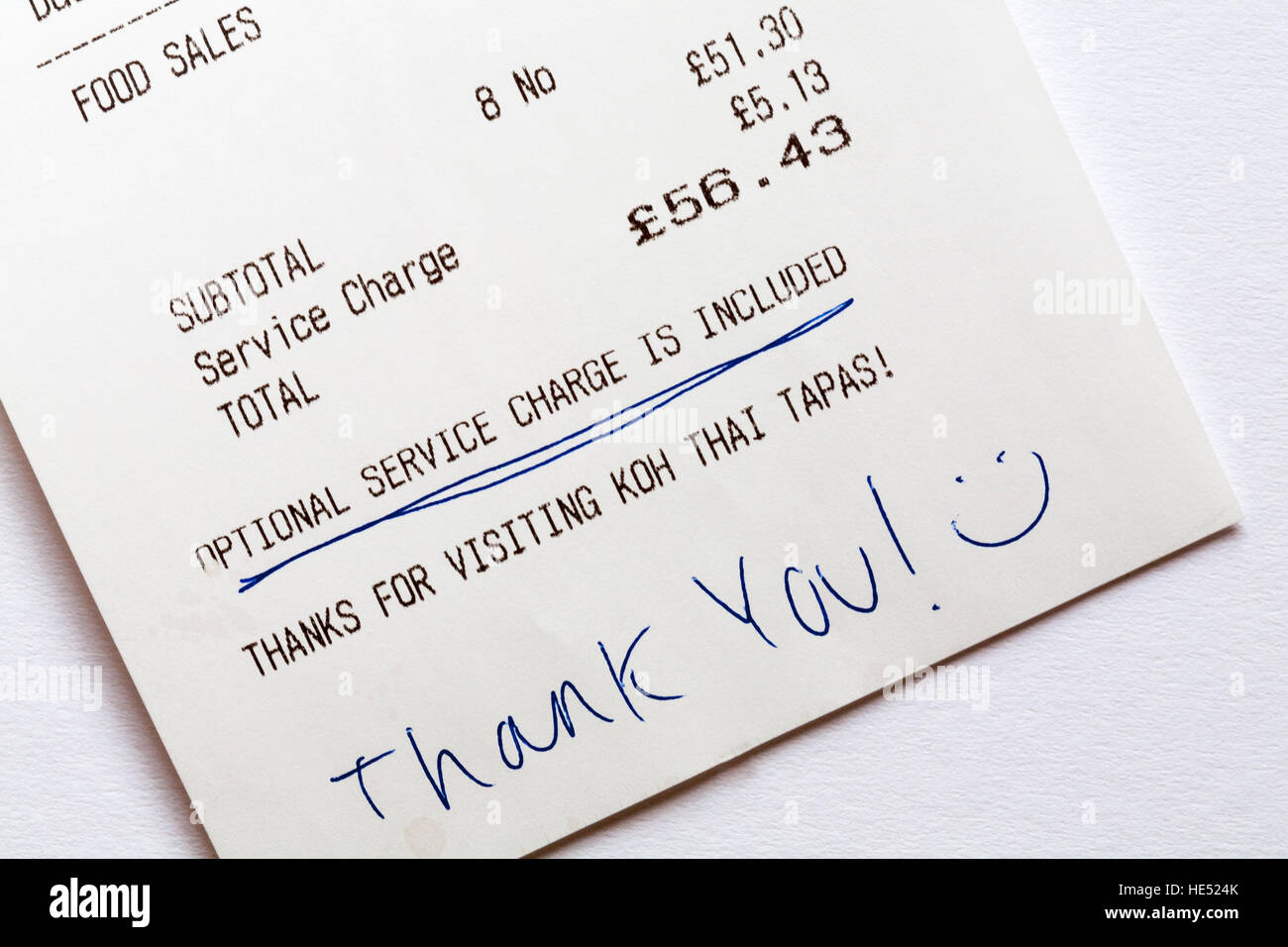 Optional service charge is included on restaurant bill with hand written thank you and smiley face Stock Photo