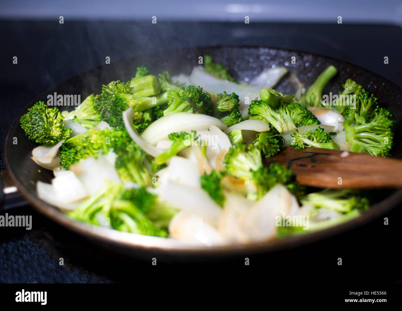 beef broccoli and onion stirfry steaming in pan Stock Photo