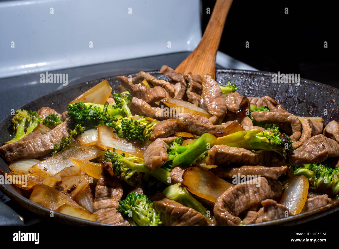 beef broccoli and onion stirfry steaming in pan Stock Photo