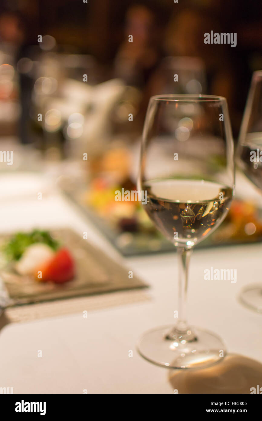 Glass of white wine on a restaurant table, background blurred Stock ...