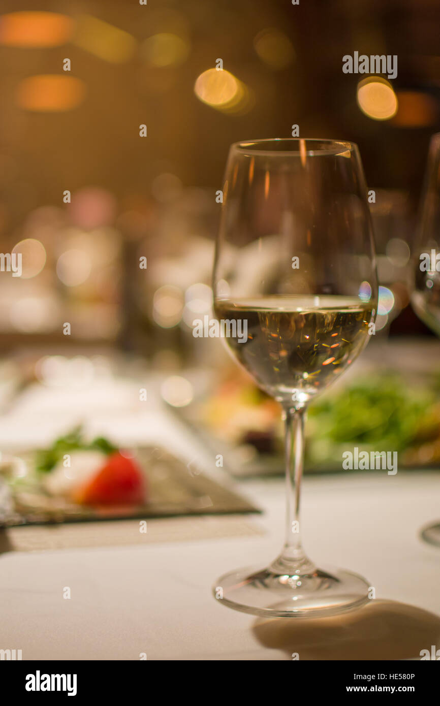 Glass of white wine on a restaurant table, background blurred Stock ...