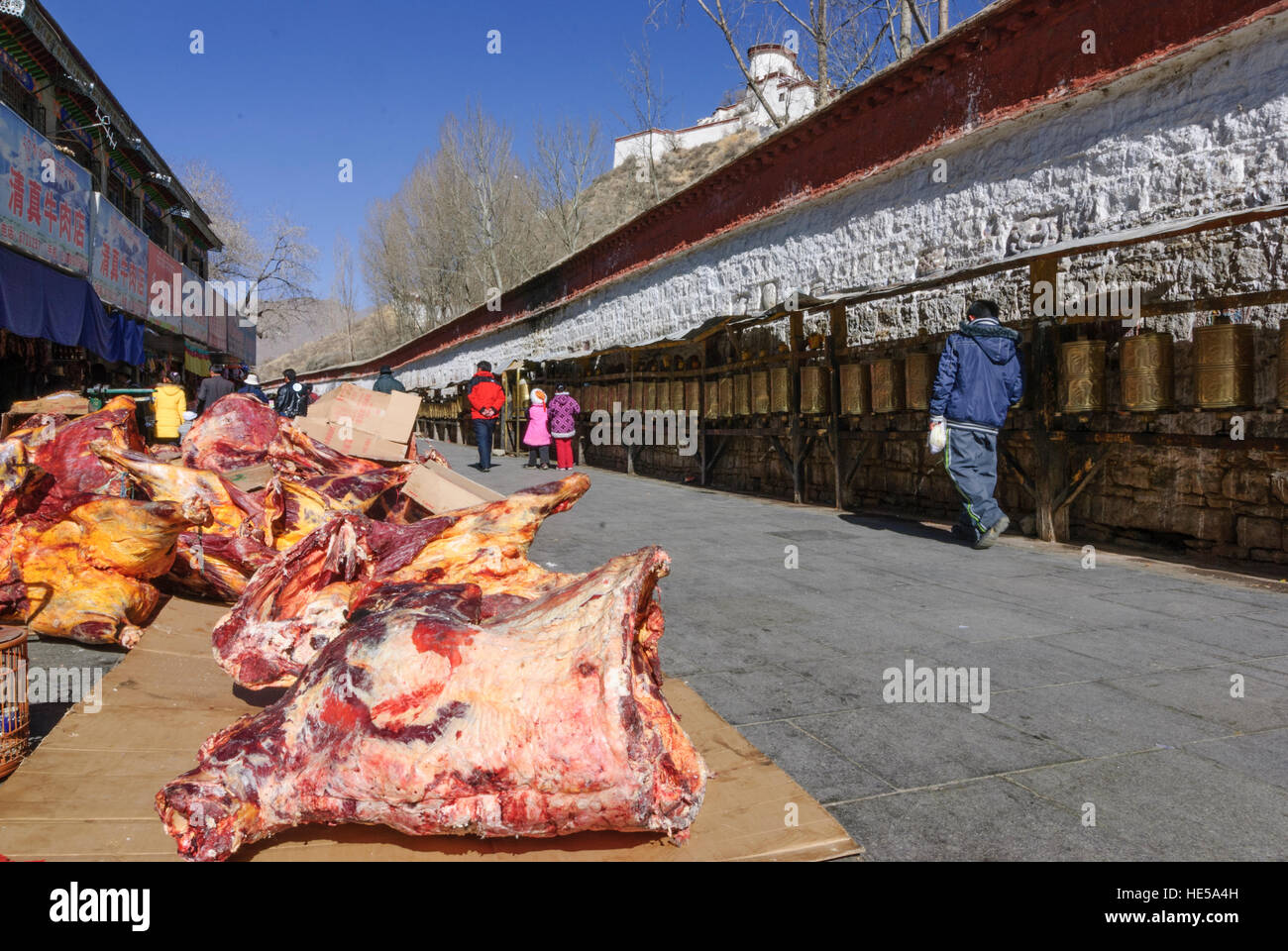 Lhasa: Dried meat waits for buyers, while Tibetans turn on the Kora (pilgrimage route) around the Potala Palace prayer mills, Tibet, China Stock Photo