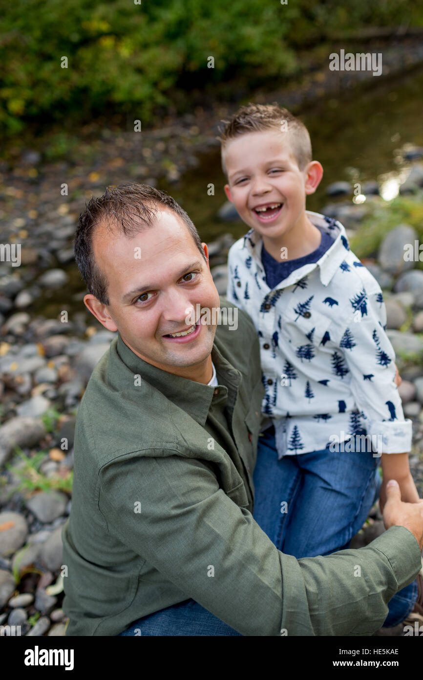 Lifestyle portrait of a young boy and his father along the banks of the McKenzie River in Oregon. Stock Photo