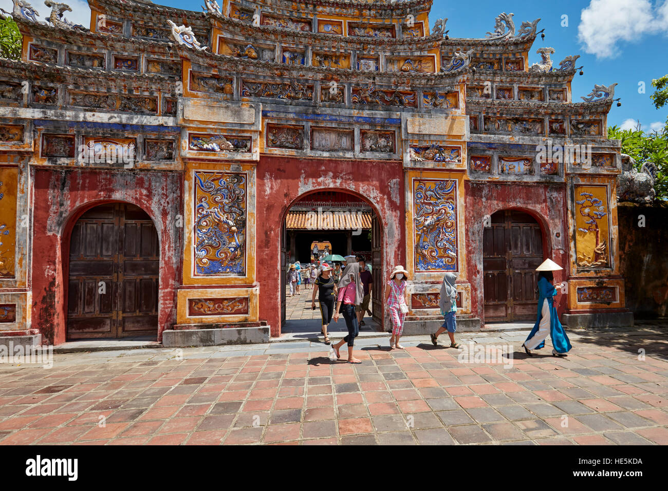 Tourists walking through a gate in the The To Mieu Temple Compound. Imperial City (The Citadel), Hue, Vietnam. Stock Photo