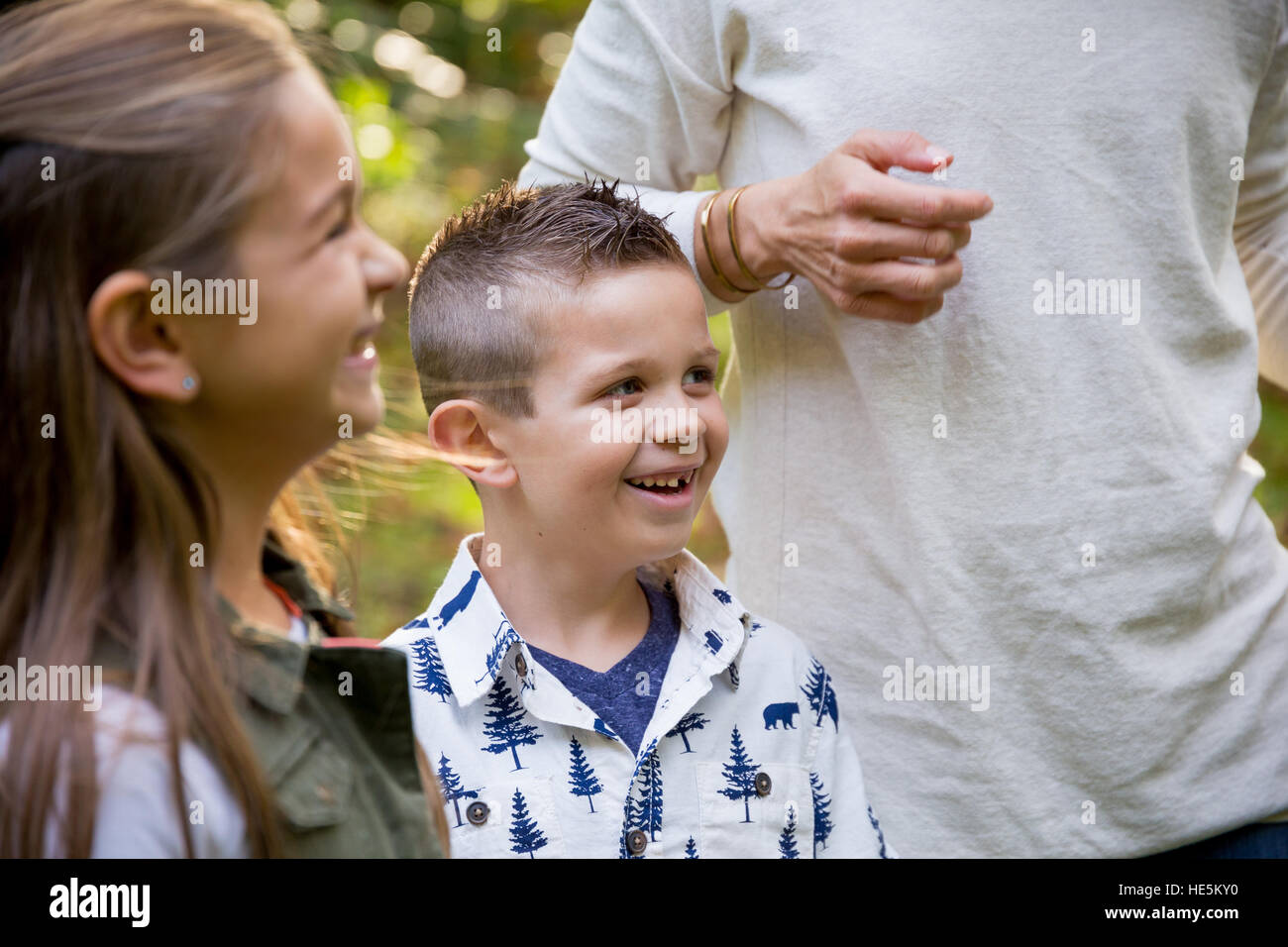 Candid lifestyle portrait of a young boy and his sister laughing and smiling at a nature park. Stock Photo