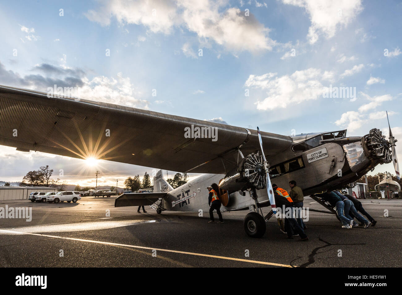 Groveland, California, USA. 16th Dec, 2016. Friday, December 16, 2016.Volunteers at Pine Mountain Lake Airport in Groveland, California, push a 1928 Ford Tri-Motor airplane toward a fuel pump, in the late afternoon.This Ford Tri-Motor NC9645, nicknamed The Tin Goose, has a wingspan of 77 feet 6 inches and was constructed in 1928. It was named the City of Wichita, and it was used to introduce the first coast-to-coast passenger air/rail service in the United States on July 7, 1929, and the development and inauguration of the first all air passenger service on October 25, 1930.Experiment Stock Photo