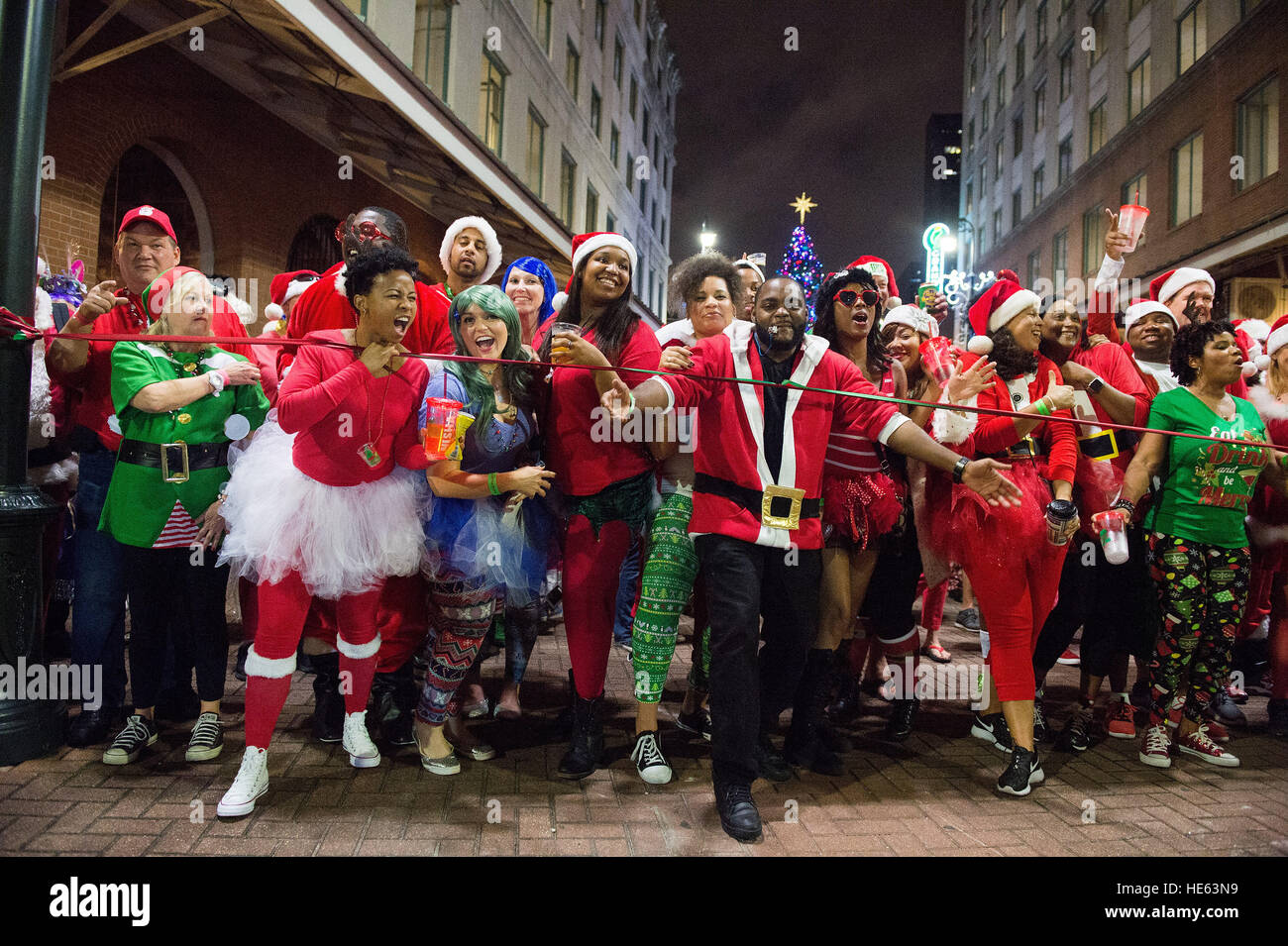 Costumed Santas'  break the start line during the 6th Annual Running of the Santas festival in New Orleans, La. on Saturday, Dec. 17, 2016. The Running of the Santas is now a national, annual bar tour that started with 40 Santas in Philadelphia with the goal to raise money for local charities. Stock Photo