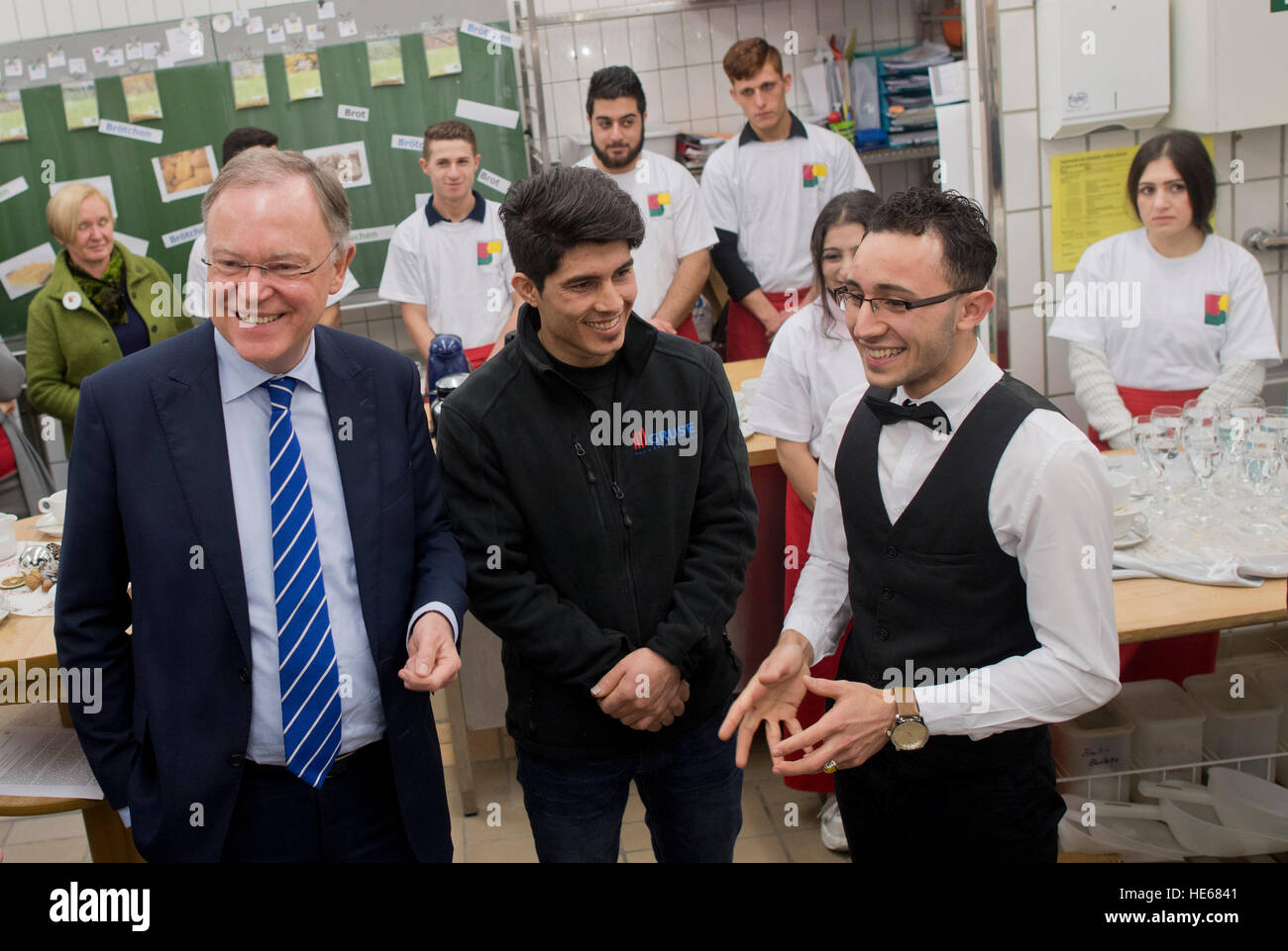 Hameln, Germany. 19th Dec, 2016. Premier of Lower Saxony Stephan Weil (l, SPD) speaking with refugees Mirwais Hashemi (c) from Afghanistan and Mohamad Hamada (r) from Syria at the Elisabeth-Selbert-Schule vocational college in Hameln, Germany, 19 December 2016. Weil was informed about the training and integration of refugees in Hameln. Photo: Julian Stratenschulte/dpa/Alamy Live News Stock Photo
