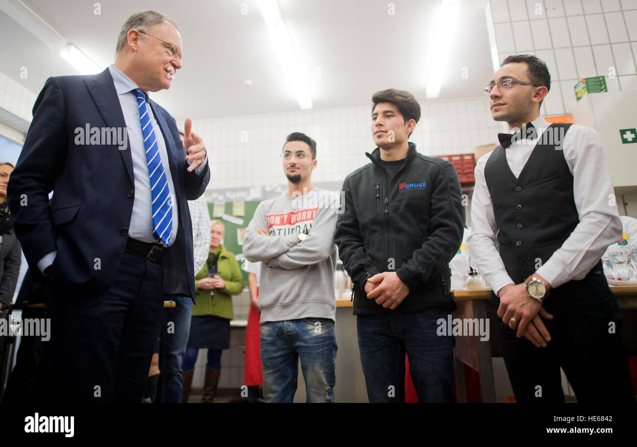Hameln, Germany. 19th Dec, 2016. Premier of Lower Saxony Stephan Weil (l-r, SPD) speaking with refugees Omid Walizadeh and Mirwais Hashemi from Afghanistan, and Mohamad Hamada from Syria at the Elisabeth-Selbert-Schule vocational college in Hameln, Germany, 19 December 2016. Weil was informed about the training and integration of refugees in Hameln. Photo: Julian Stratenschulte/dpa/Alamy Live News Stock Photo