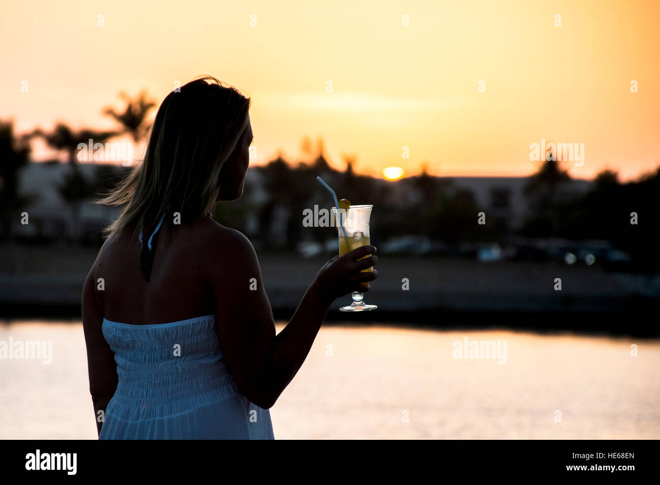 Amazing Sunset girl drink glass cocktail in Sultanate Oman at Souly Bay harbour and Hotels Oceanside Stock Photo