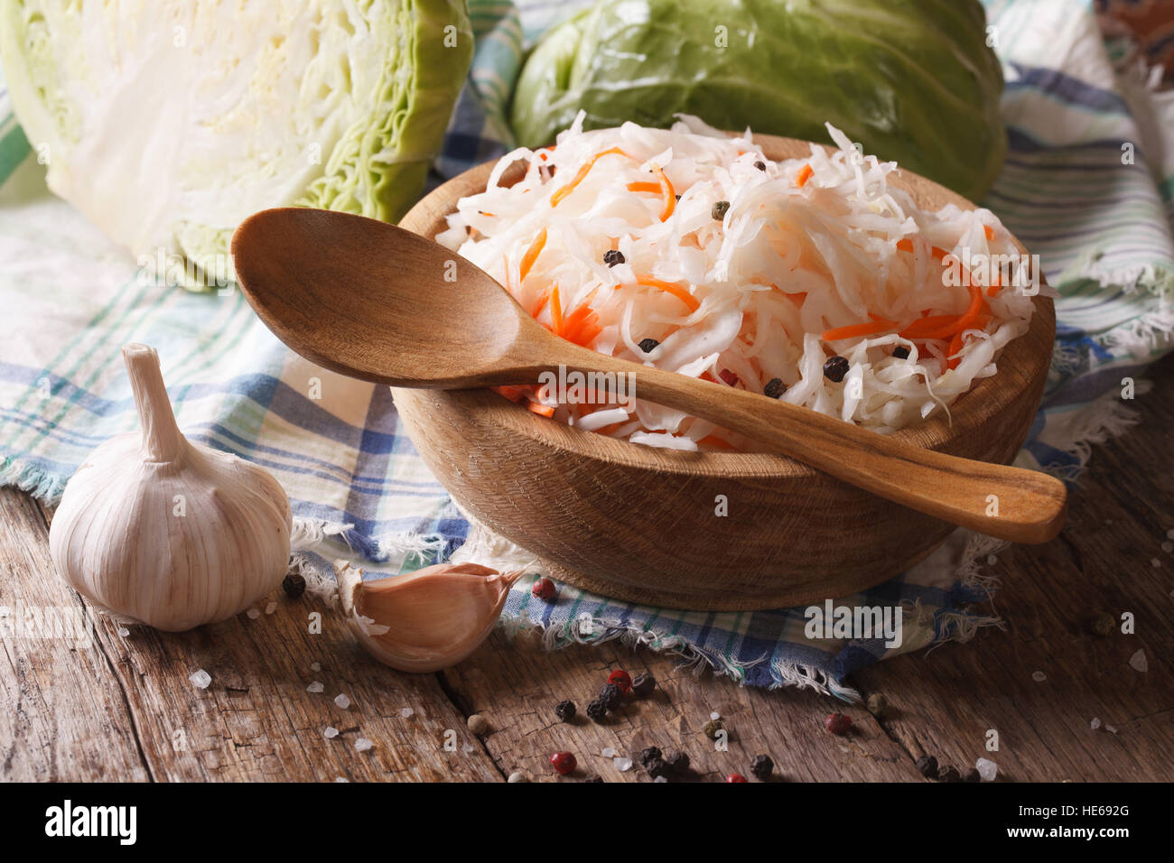 sauerkraut and carrots in a wooden plate closeup and ingredients. horizontal, rustic Stock Photo