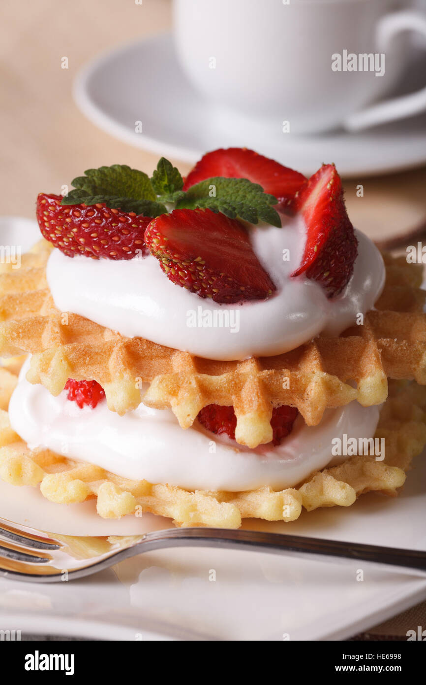 Waffles with fresh strawberry and cream close-up on a plate. vertical Stock Photo