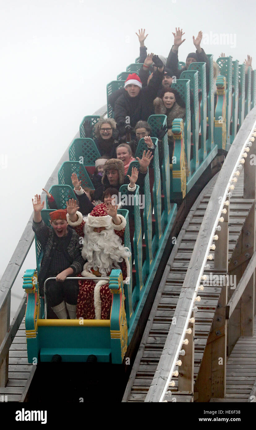People dressed as Santa and elves rides the Scenic Railway at Dreamland in Margate, Kent, to celebrate the re-opening of the ride, guests who come to the park before Christmas in full Father Christmas outfit can ride for free. Stock Photo