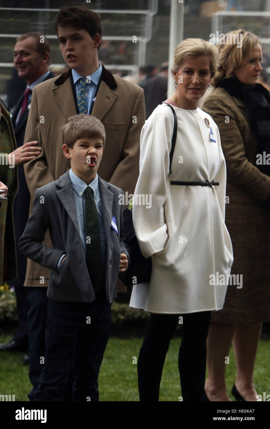 James, Viscount Severn, pulls a funny face for photographers as he and his mother, the Countess of Wessex, watch the horses in the parade ring during the Christmas Racing Weekend at Ascot, Berkshire. Stock Photo