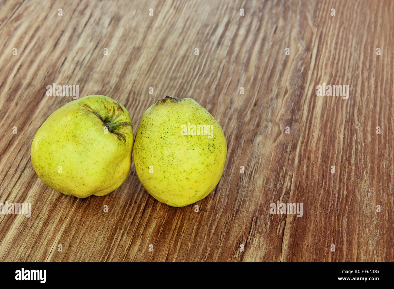 Two appetizing ripe quince on grunge wooden background. Stock Photo