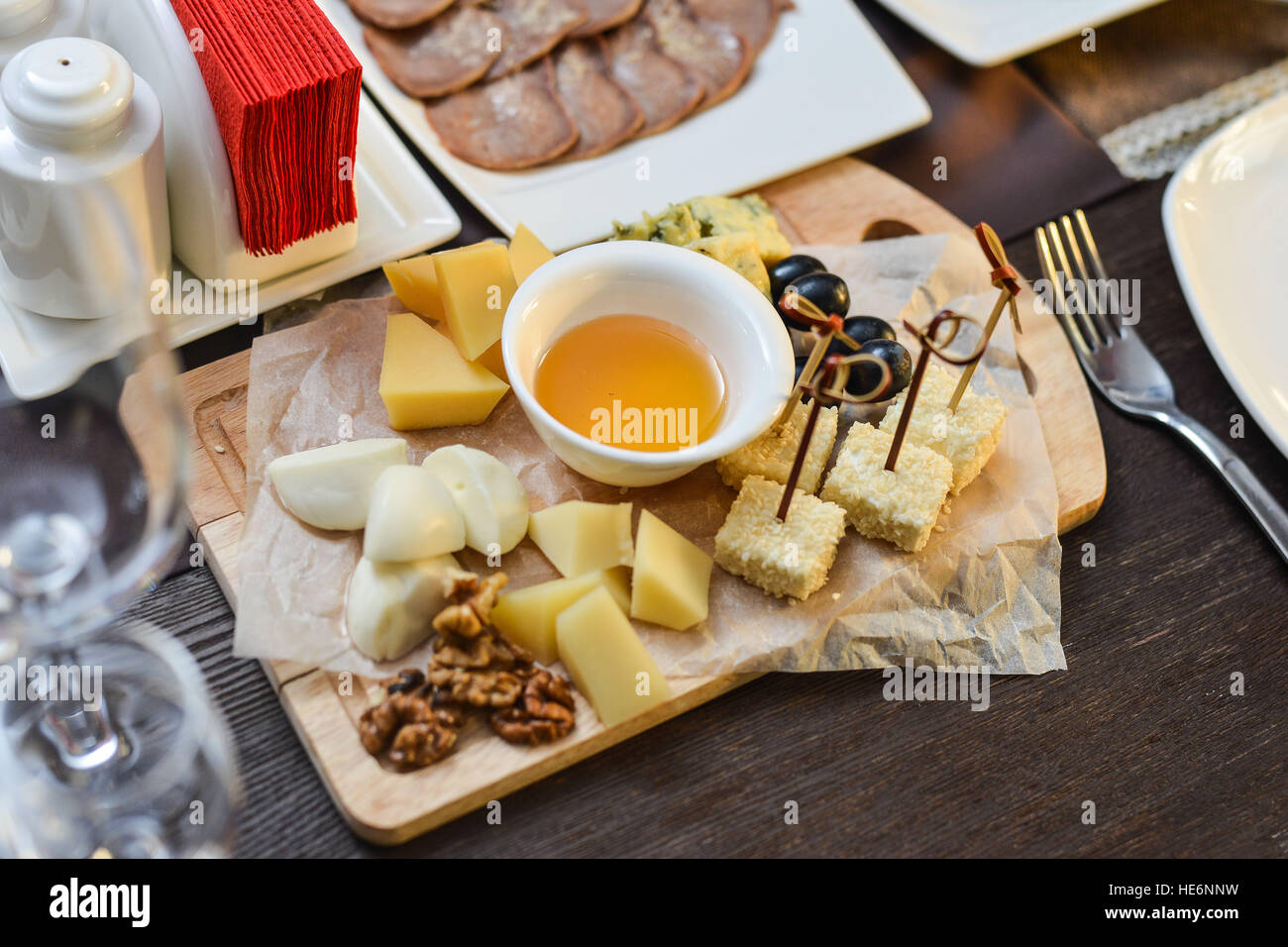 Cheese plate with cheeses Dorblu, Parmesan, Brie, Camembert and Roquefort in serving on the table from an old tree close-up Stock Photo