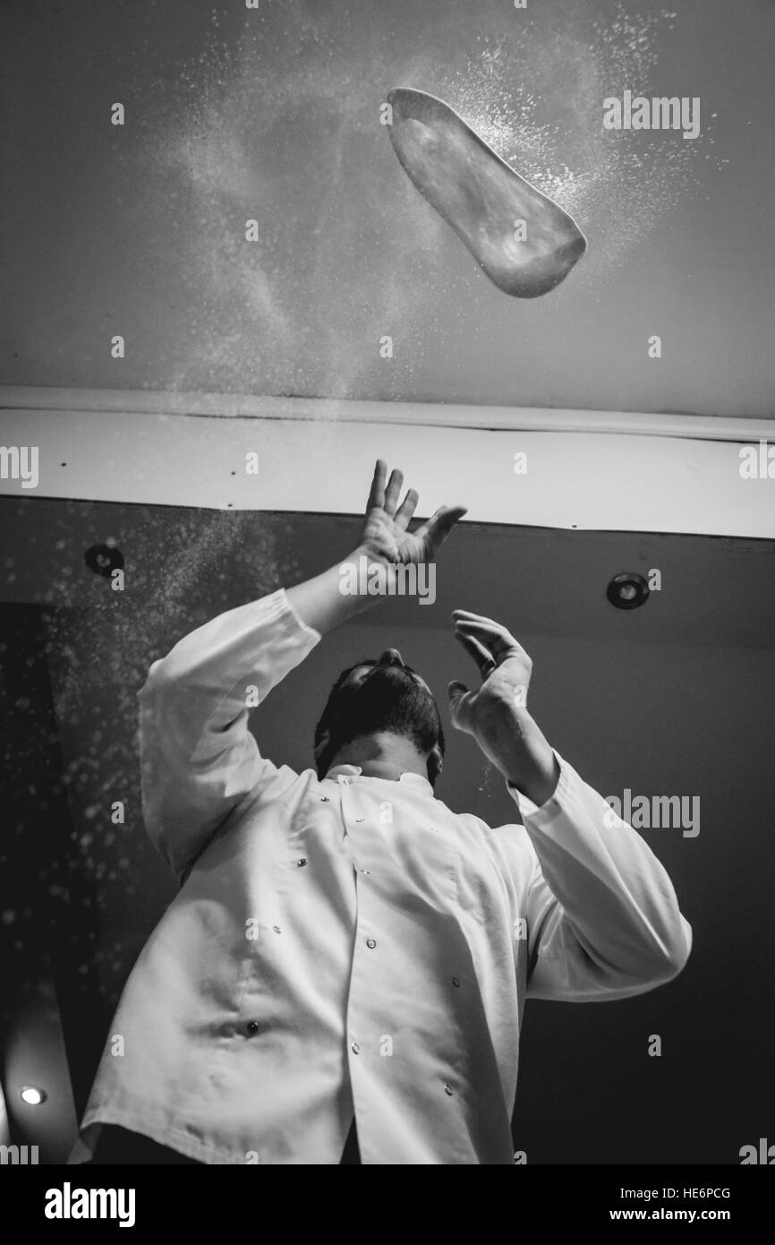 Chef throwing pizza base dough in black & white Stock Photo
